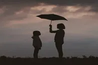 Adult holding a umbrella with a child